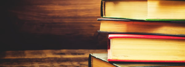stack of books on the dark wood background. toning. selective focus on the middle book